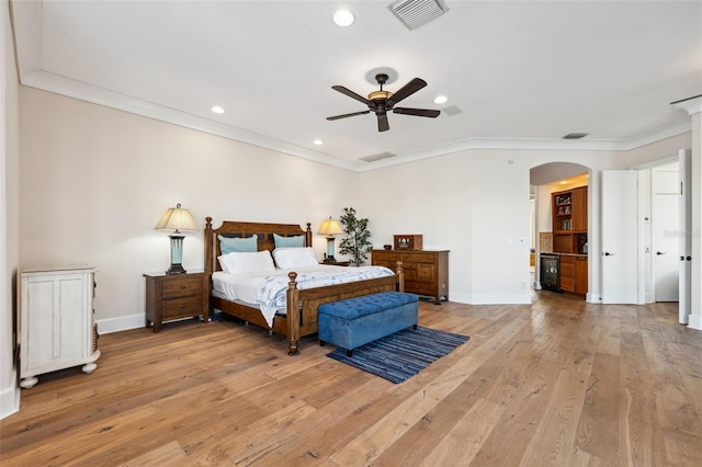 bedroom featuring ceiling fan, crown molding, and light hardwood / wood-style floors