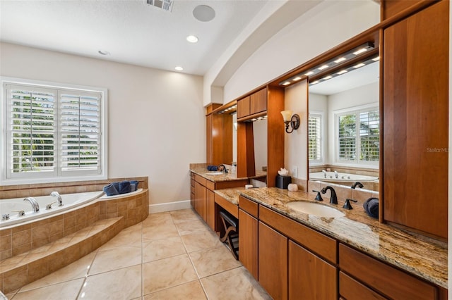 bathroom featuring tiled bath, vanity, and tile patterned flooring