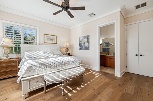 bedroom with light hardwood / wood-style flooring, a closet, ensuite bath, ceiling fan, and ornamental molding