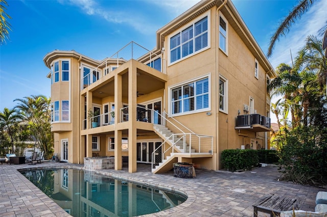 back of property with ceiling fan and a patio area