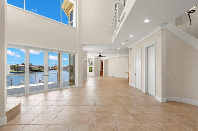 6015 Kipps Colony Dr E, Gulfport, FL 33707 - spare room featuring a water view, light tile patterned flooring, recessed lighting, a towering ceiling, and french doors