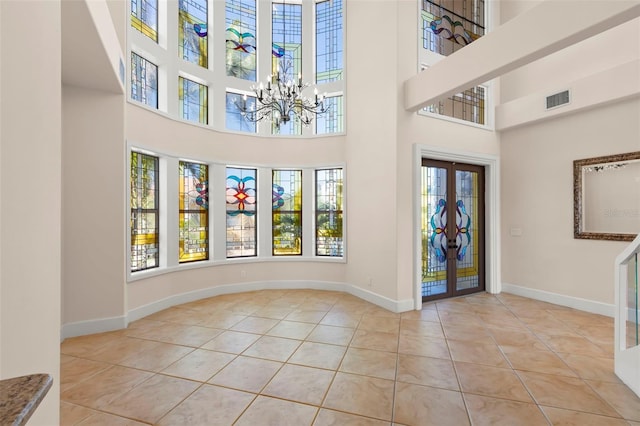 6015 Kipps Colony Dr E, Gulfport, FL 33707 - entryway featuring a chandelier, french doors, tile patterned flooring, and a high ceiling