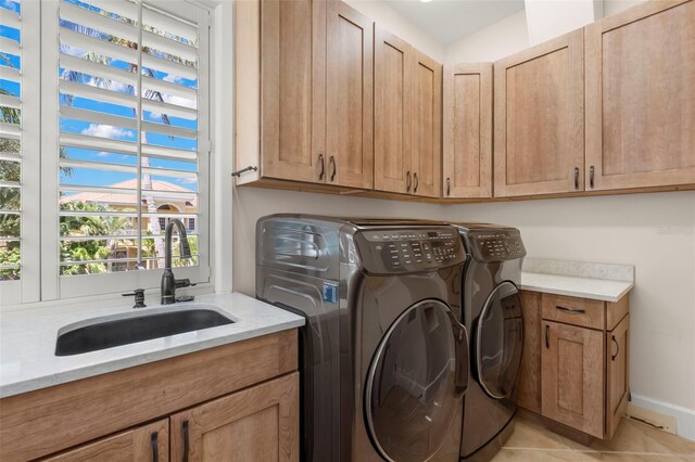 6015 Kipps Colony Dr E, Gulfport, FL 33707 - laundry area with cabinet space, washer and clothes dryer, and light tile patterned flooring