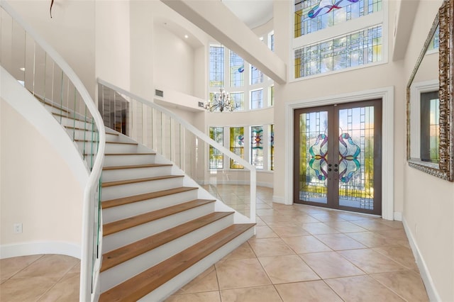 6015 Kipps Colony Dr E, Gulfport, FL 33707 - entrance foyer with a high ceiling, french doors, tile patterned flooring, stairs, and a chandelier