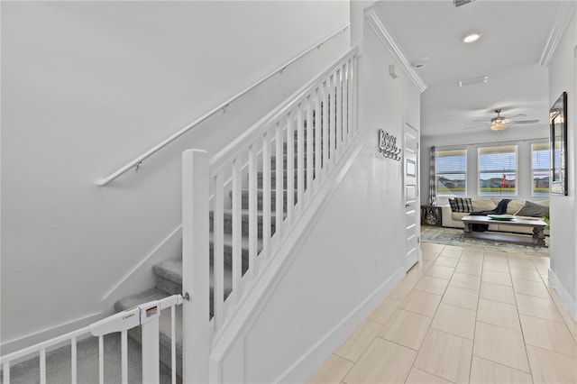 stairs with tile patterned floors, ceiling fan, and ornamental molding