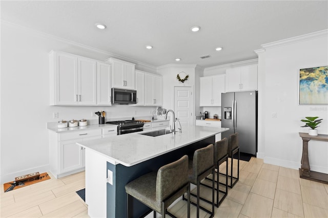 kitchen with white cabinetry, sink, an island with sink, and stainless steel appliances