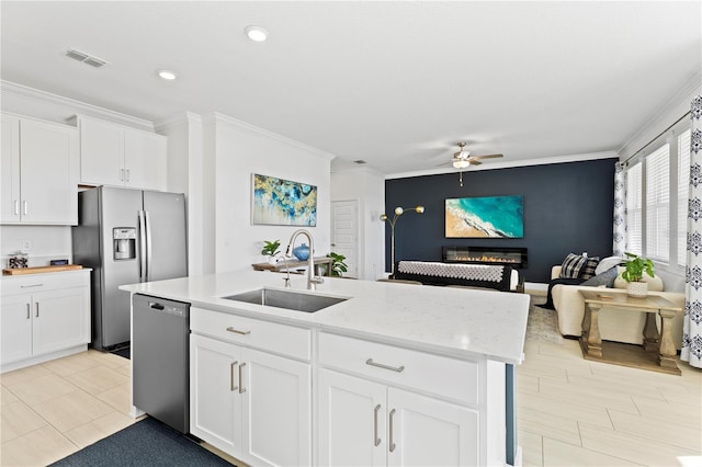 kitchen featuring white cabinets, appliances with stainless steel finishes, an island with sink, and sink