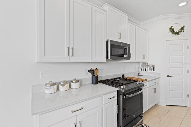 kitchen featuring light stone countertops, white cabinetry, stainless steel appliances, and light tile patterned floors