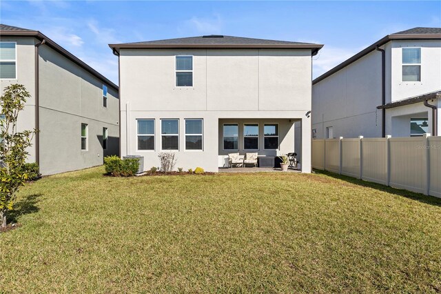 back of house featuring a lawn and a patio area