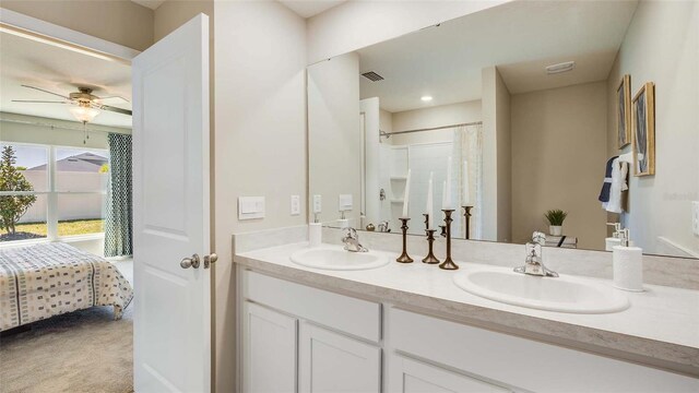 bathroom featuring ceiling fan, walk in shower, and vanity