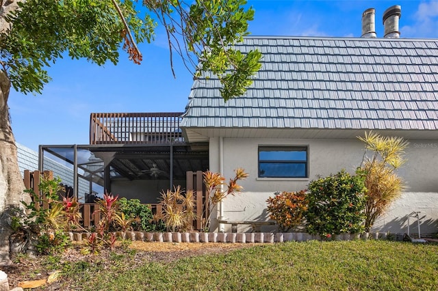 view of side of home featuring a lanai and a lawn