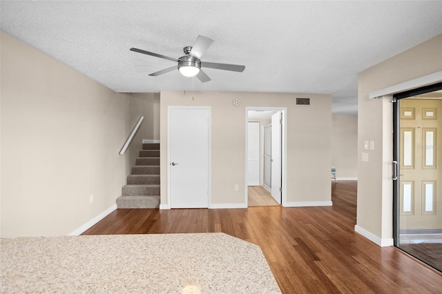 unfurnished living room with hardwood / wood-style floors, a textured ceiling, and ceiling fan