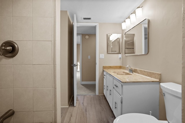 bathroom featuring vanity, hardwood / wood-style floors, and toilet