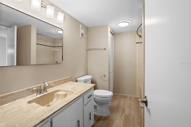 bathroom with hardwood / wood-style flooring, vanity, and toilet