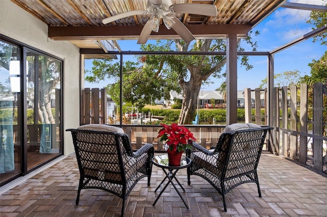 sunroom / solarium with beamed ceiling, ceiling fan, and wood ceiling