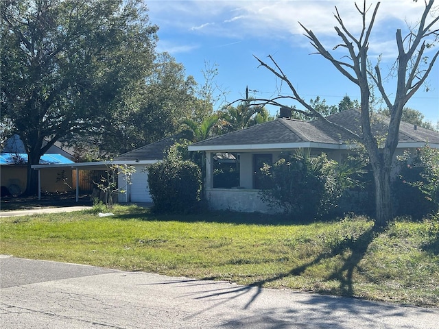 view of front of home featuring a front lawn and a carport