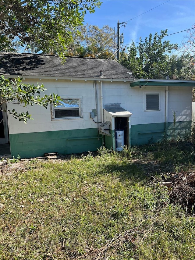 rear view of house featuring a lawn