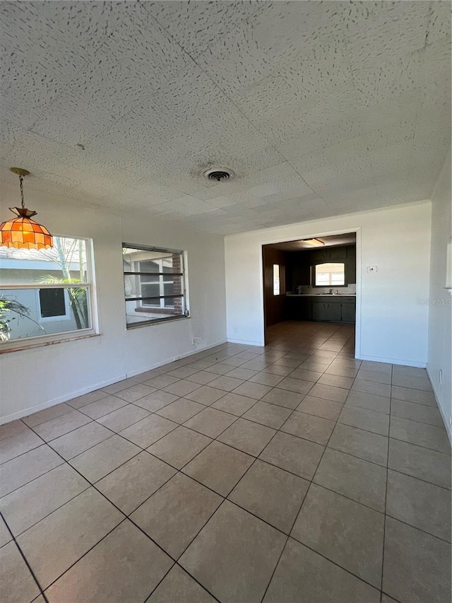 empty room featuring tile patterned floors and a wealth of natural light