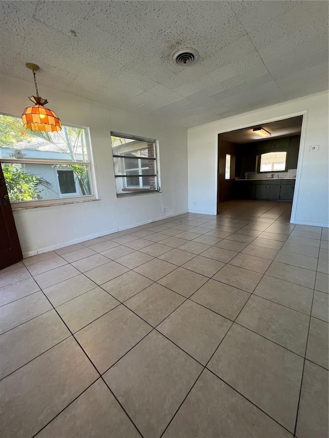 unfurnished room featuring light tile patterned floors and a healthy amount of sunlight