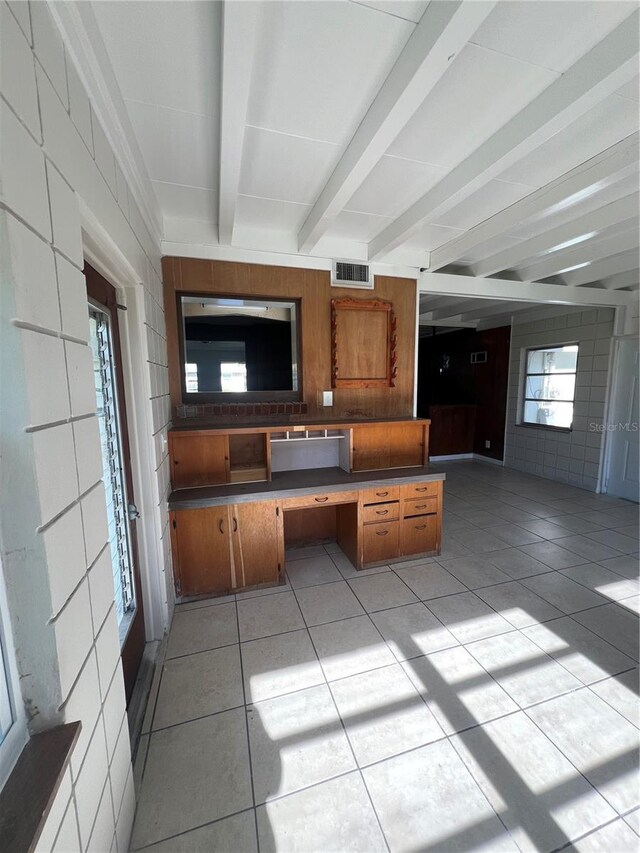 kitchen with beam ceiling, built in desk, and light tile patterned flooring