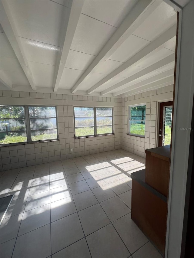 unfurnished sunroom with beam ceiling