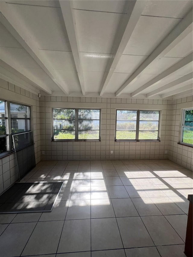 unfurnished sunroom with beam ceiling