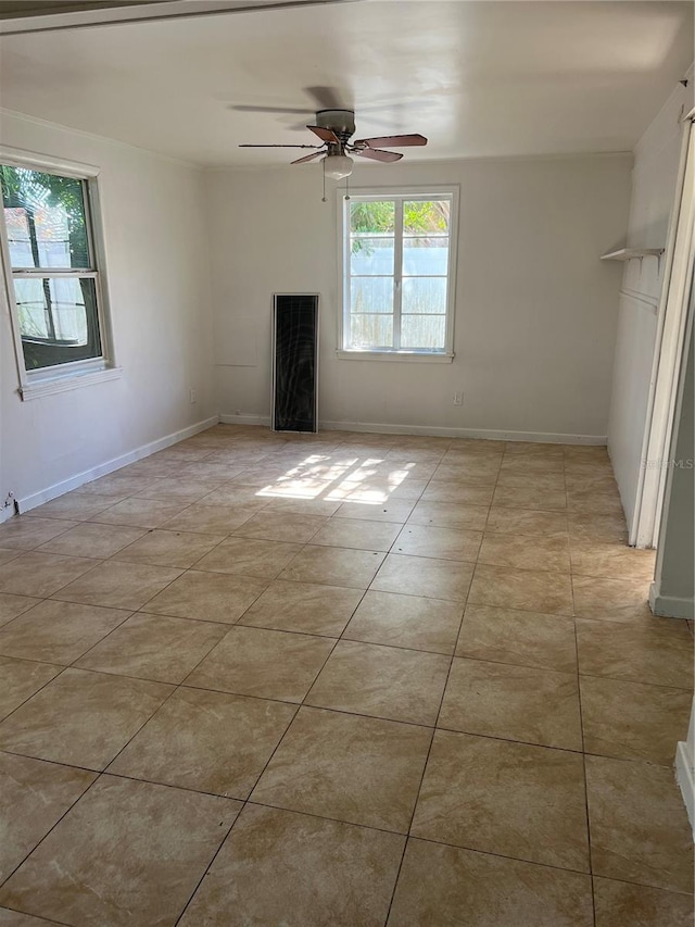 tiled spare room featuring a wealth of natural light and ceiling fan