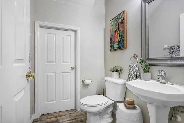 bathroom with toilet and wood finished floors