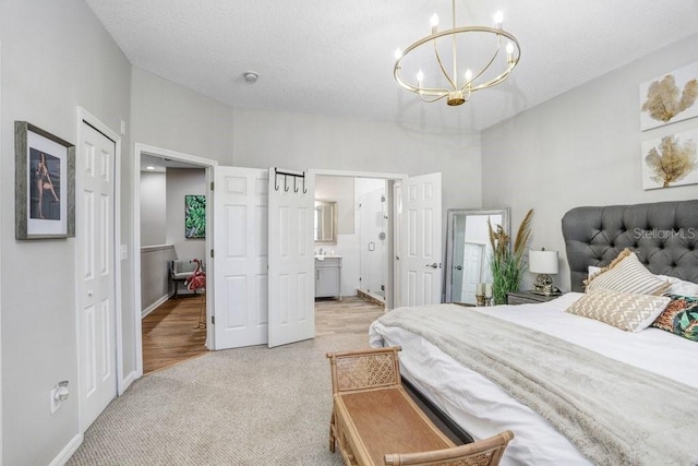 carpeted bedroom with connected bathroom and an inviting chandelier