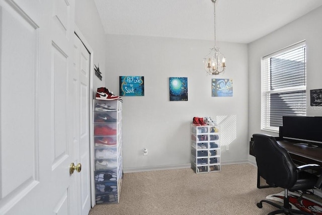 home office with a chandelier and carpet flooring