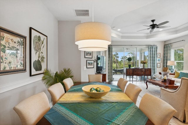 dining area featuring ceiling fan, crown molding, and a tray ceiling