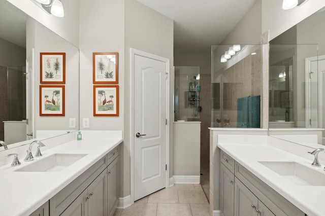 bathroom with tiled shower, vanity, and tile patterned flooring