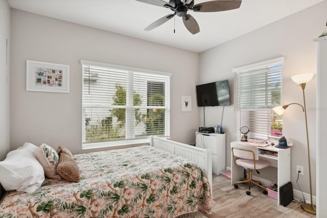 bedroom with ceiling fan, light hardwood / wood-style floors, and multiple windows