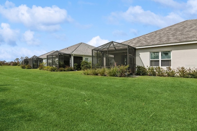 rear view of house with a lanai and a yard