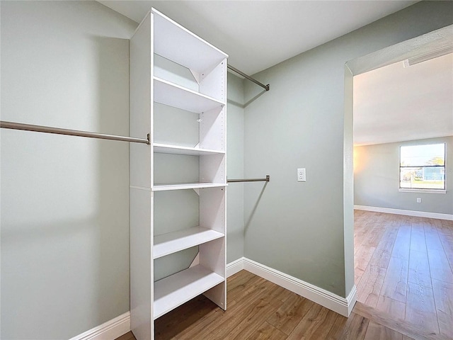 spacious closet with hardwood / wood-style floors