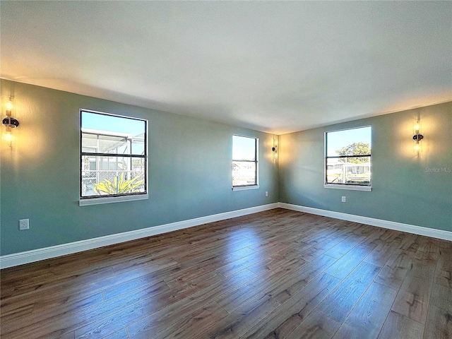 spare room featuring a wealth of natural light and dark hardwood / wood-style floors