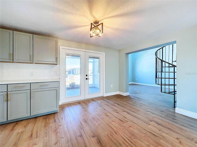 entryway featuring light wood-type flooring, a textured ceiling, and french doors