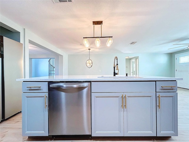 kitchen with ceiling fan, sink, stainless steel dishwasher, decorative light fixtures, and a kitchen island with sink