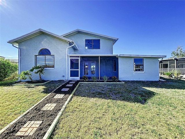 view of front of house with french doors and a front lawn