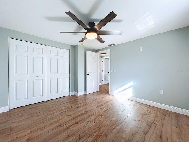 unfurnished bedroom with wood-type flooring, a closet, and ceiling fan