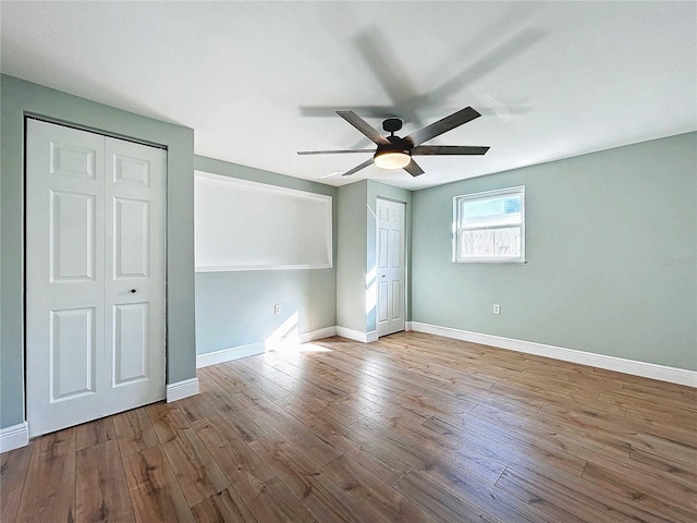 unfurnished bedroom with multiple closets, ceiling fan, and light hardwood / wood-style floors