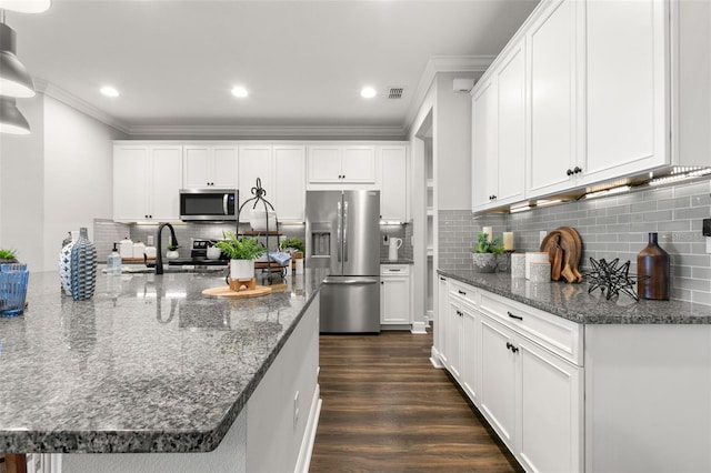 kitchen with sink, appliances with stainless steel finishes, white cabinetry, dark hardwood / wood-style floors, and dark stone counters