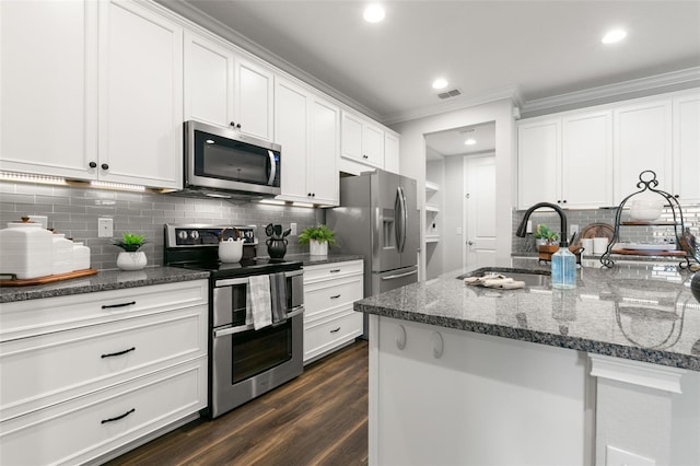 kitchen with sink, dark stone counters, dark hardwood / wood-style floors, stainless steel appliances, and white cabinets