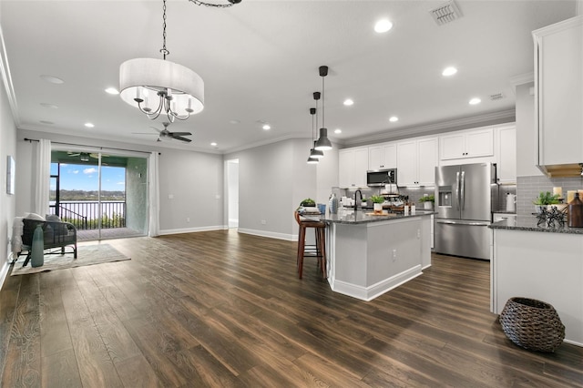 kitchen with pendant lighting, ceiling fan with notable chandelier, stainless steel appliances, and white cabinets