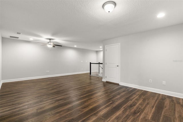 spare room with ceiling fan, dark hardwood / wood-style flooring, and a textured ceiling