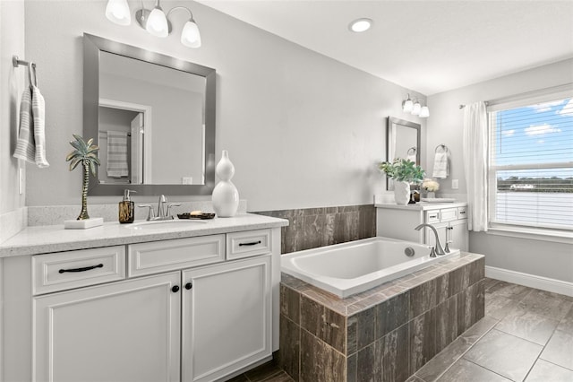 bathroom with vanity and tiled bath