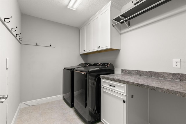 laundry room with cabinets, light tile patterned floors, a textured ceiling, and independent washer and dryer