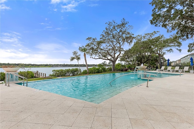 view of swimming pool featuring a water view and a patio