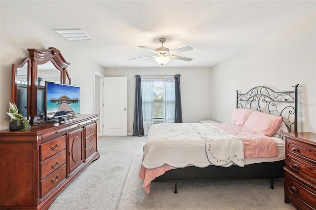 bedroom with light carpet, a textured ceiling, and ceiling fan