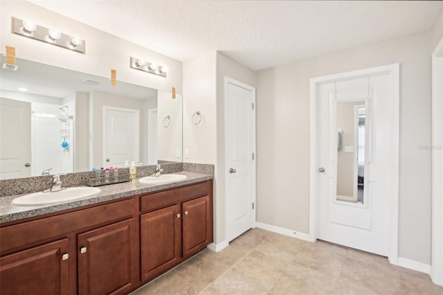 bathroom featuring vanity, a shower with door, and a textured ceiling